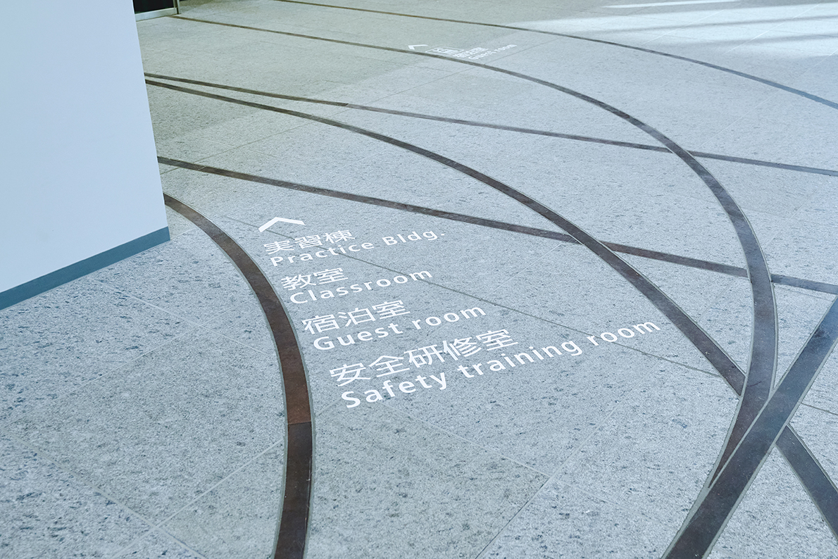 鐵路線的設計標記了通往這些會室的動線，讓空間移動成為可能。為了捕捉會社的特色和創意美學風格，我們也使用鐵軌廢料來製作訓練所的招牌和部分的樓梯。同時，二樓的設計運用東鐵各鐵路線的顏色來為會室編碼，並設計相對應的鑰匙卡。鑰匙卡上有代表鐵路支段的鐵路線。這些卡片可以和許多不同的路線圖配對。透過這項設計，我們希望打造一個空間，幫助受訓者感受其工作上的榮耀。