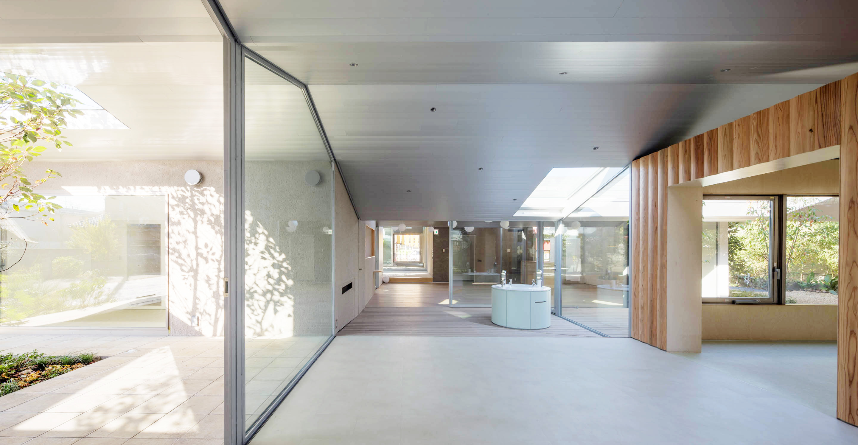 診間和院子交錯,為小病人們提供舒適的綠色氛圍。樹兒和灌木也作為各區域的隱私保障。延伸的「山與谷」屋頂就像是社區裡的人字形屋頂,在這個混融的場景之上漂浮著,並為訪客創造出高聳的頂蓬。