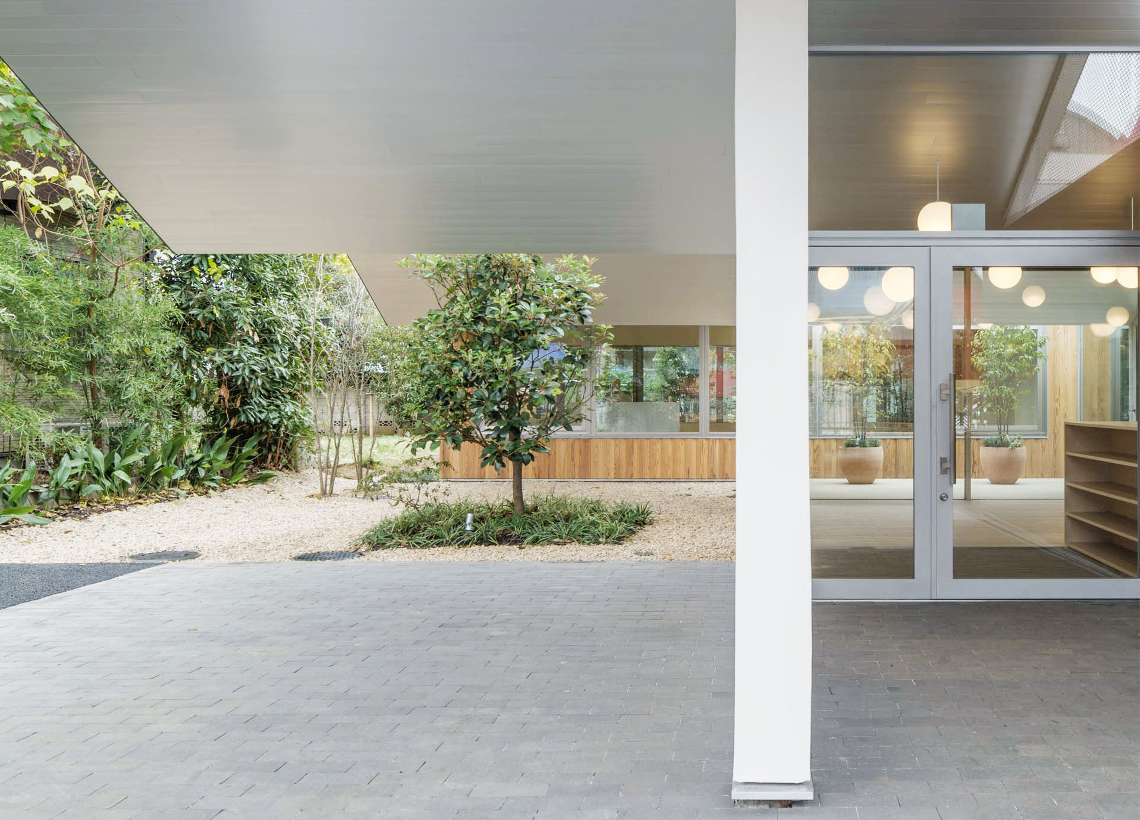 私人花園設有圍牆,以屏蔽診所訪客的視線,不過磚頭之間的縫隙仍可讓林木鑽進建築和延伸到街上。